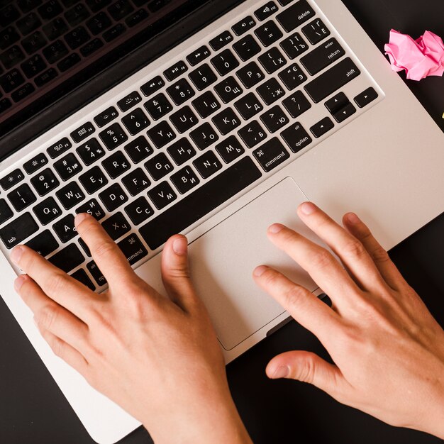 An overhead view of person's hand typing on laptop