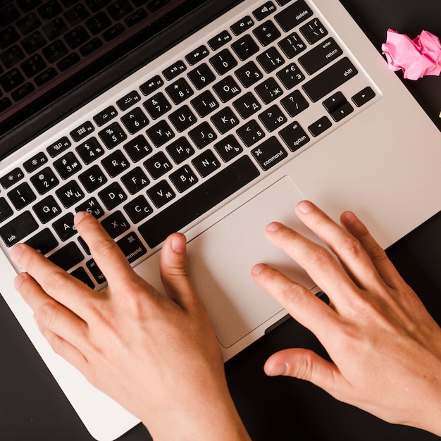 An overhead view of person's hand typing on laptop