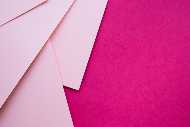 Overhead view of pink cardboard papers on magenta backdrop