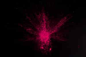 Free photo overhead view of pink color exploding on black surface