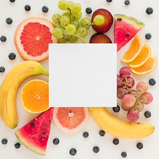 An overhead view of placard over the fresh healthy fruits on white backdrop