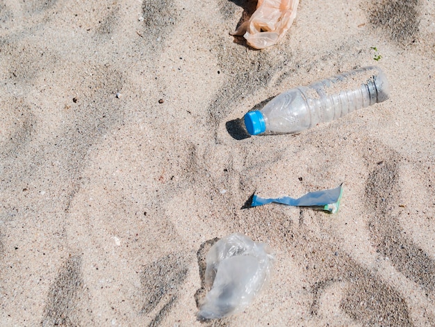 Overhead view of plastic trash on sand at beach