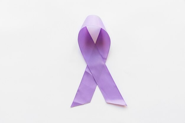 Overhead view of purple awareness ribbon on white background