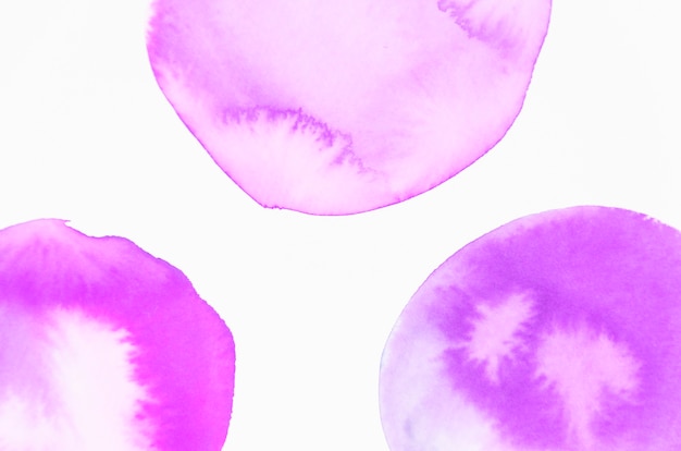 An overhead view of purple watercolor circle isolated on white backdrop