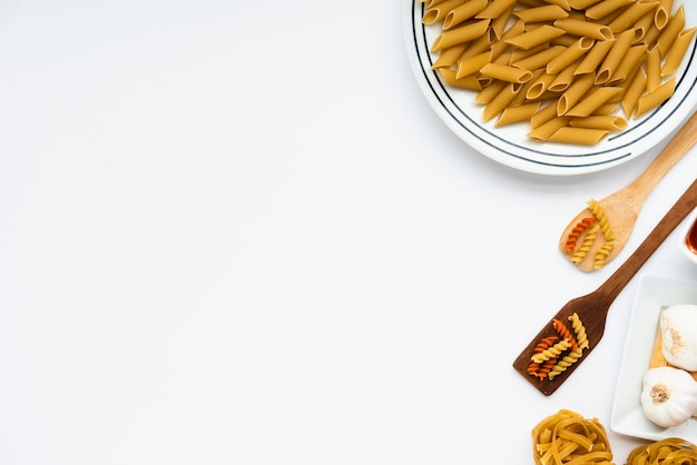 Free photo overhead view of raw italian pasta over white background