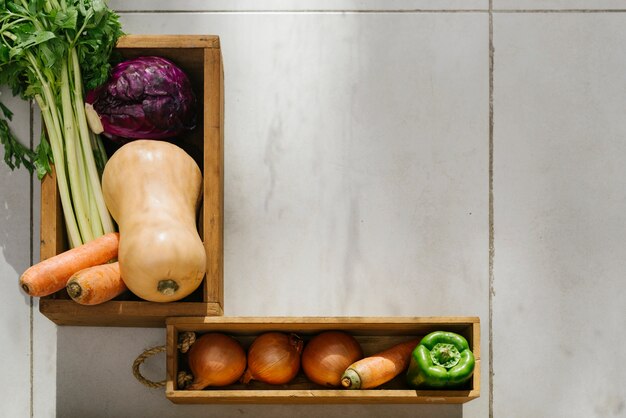 Overhead view of raw vegetables on tiled floor