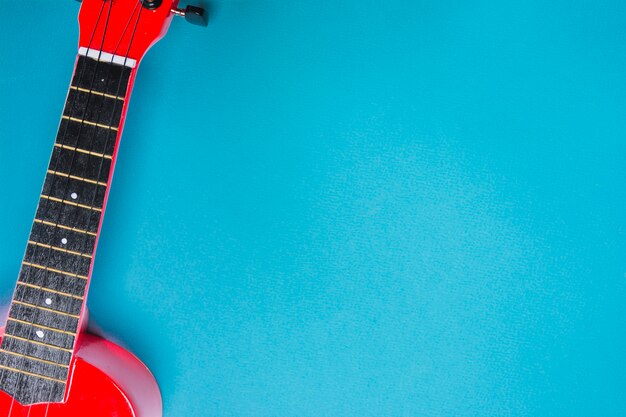 青色の背景に赤いアコースティック・クラシック・ギターのオーバーヘッド・ビュー