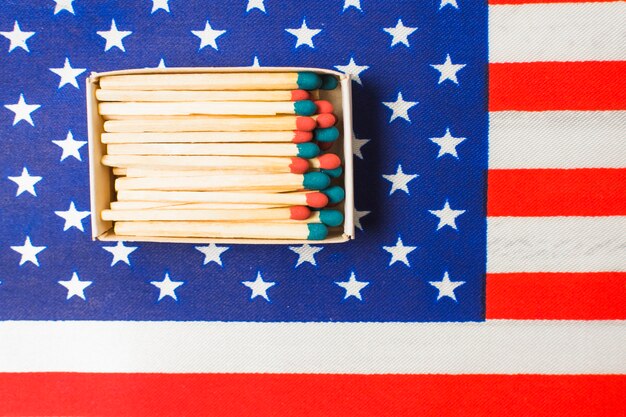 An overhead view of red and blue matchstick on american flag