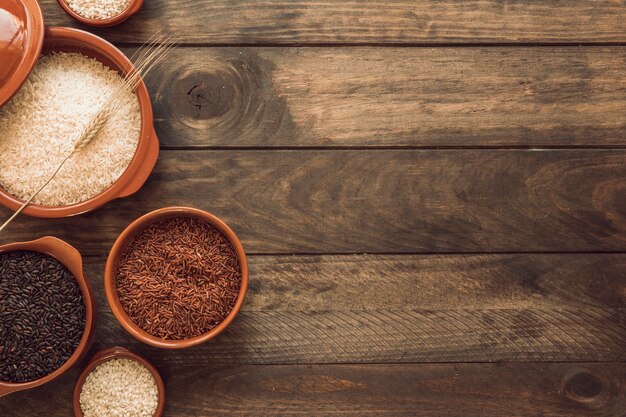 Overhead view of red; brown and white rice bowls on wooden background