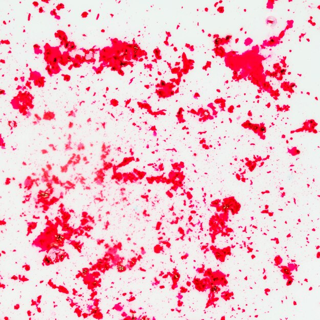 An overhead view of red color powder on white background