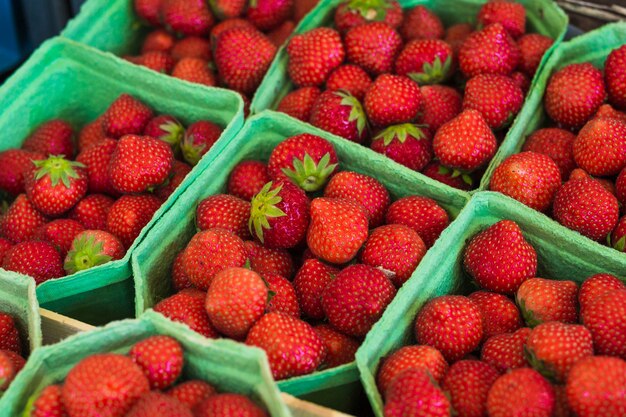 An overhead view of red juicy strawberries in the green case