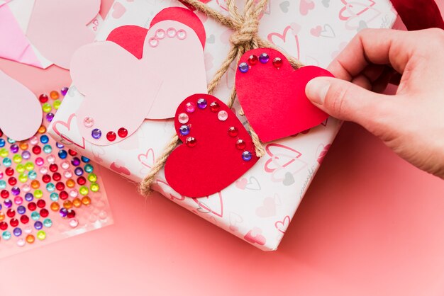 An overhead view of red and pink heart shape on wrapped gift box