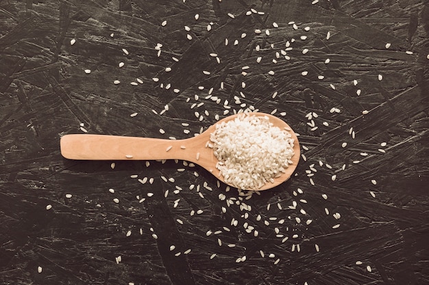 An overhead view of rice grains on wooden spoon