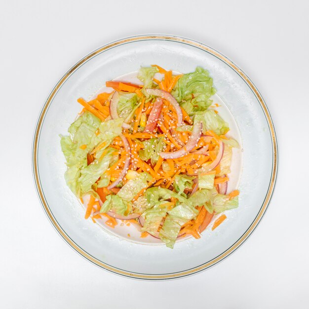 Overhead view of salad on plate on white background