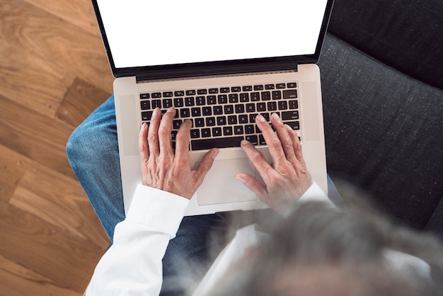 An overhead view of senior man typing on laptop