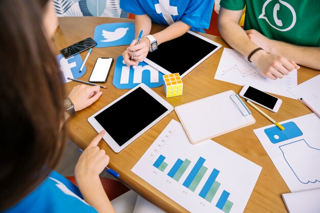 Overhead view of skillful people using digital tablet at workplace