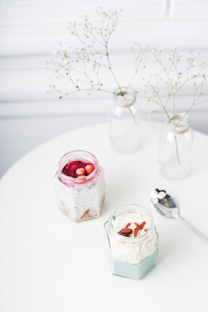 An overhead view of smoothies jar; spoon and vase on table