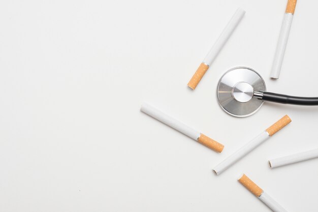 Overhead view of stethoscope with cigarettes over isolated on background