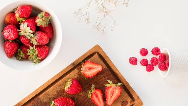 An overhead view of strawberries; and raspberries with gypsophila flower isolated on white background