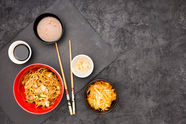 An overhead view of tasty chinese food over black surface