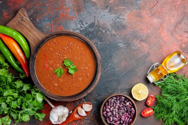 混合色のテーブルのまな板にトマトスープ落ちたオイルボトル豆の俯瞰図
