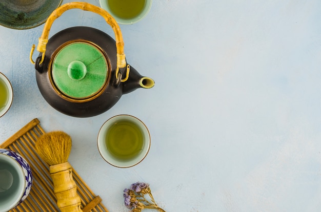 An overhead view of traditional chinese teaware with brush on white background