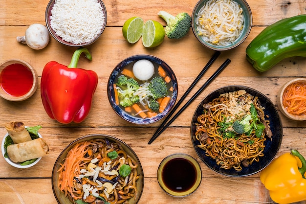 An overhead view of traditional thai food with sauces on wooden plank