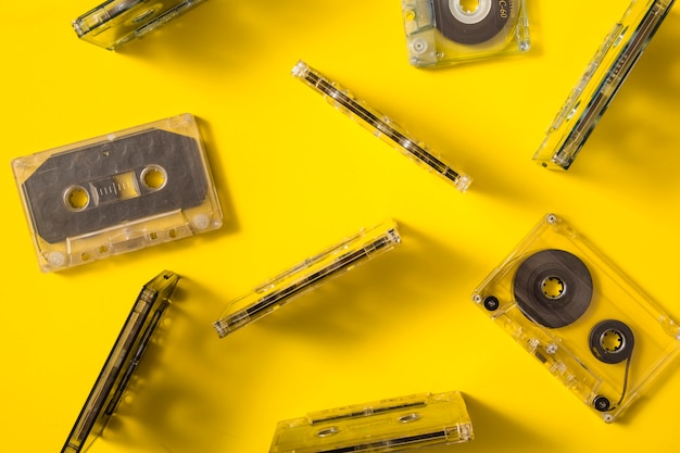 Overhead view of transparent audio cassette tapes on colored background