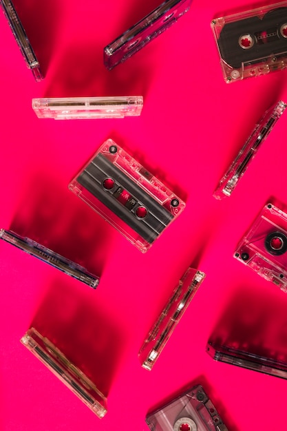 Вид сверху прозрачной кассетной ленты на розовом фоне