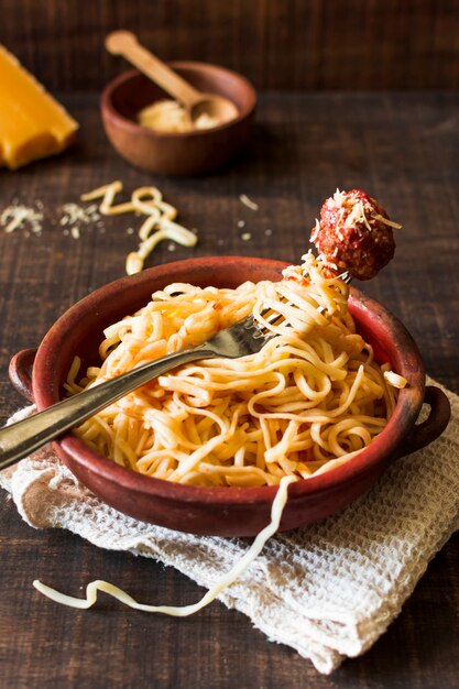 An overhead view of trenette pasta with single meat ball on fork