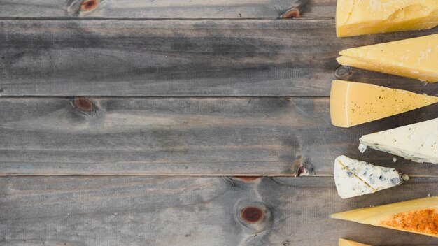 An overhead view of triangular cheese wedges on wooden table