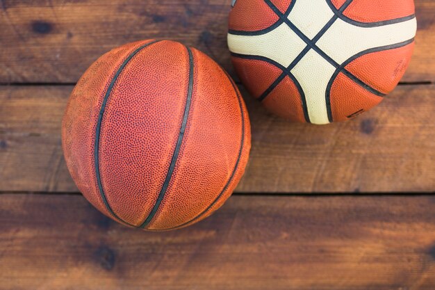 木製のテクスチャの背景に2つのバスケットボールのオーバーヘッドビュー