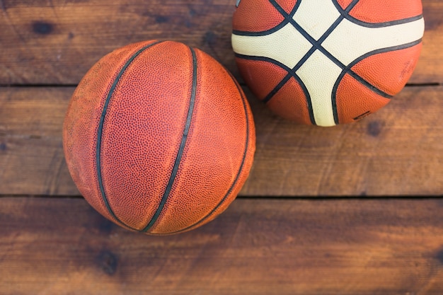 An overhead view of two basketball on wooden textured background