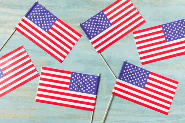 An overhead view of usa flags on blue wooden textured background