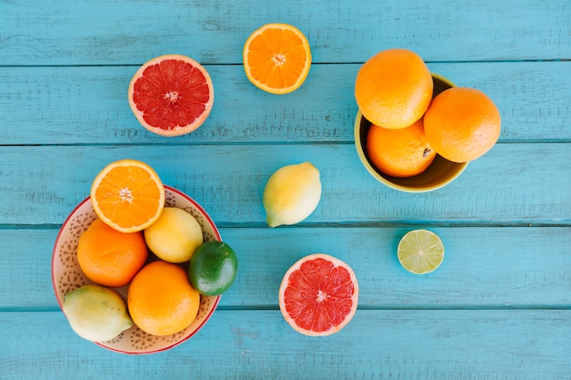 Free photo overhead view of various citrus fruits on blue wooden background