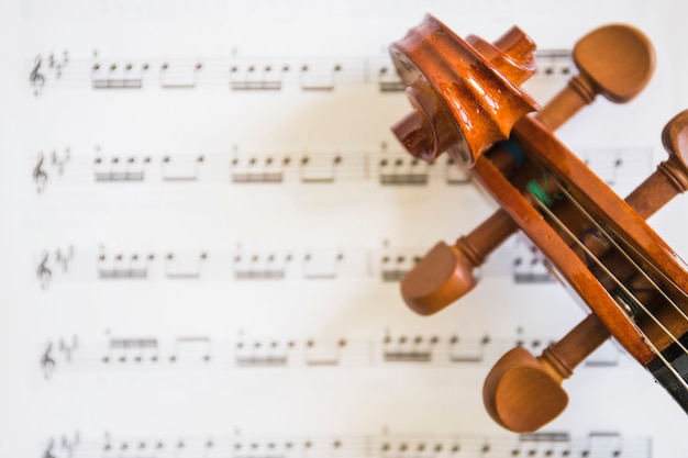 An overhead view of violin scroll and strings on musical notes