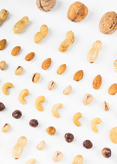 An overhead view of walnuts; peanuts; almonds; pistachios; hazelnut and cashew nuts on white background