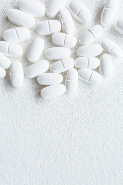 Overhead view of white pills on rough background