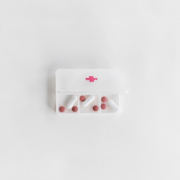 Overhead view of white plastic pill organizer on white background