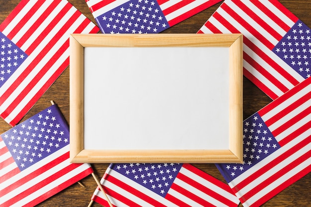 Free photo an overhead view of whiteboard frame on usa american flags