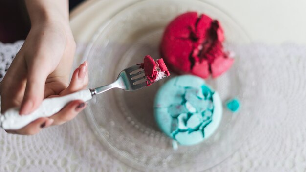 An overhead view of woman's hand eating ice cream sandwich with fork