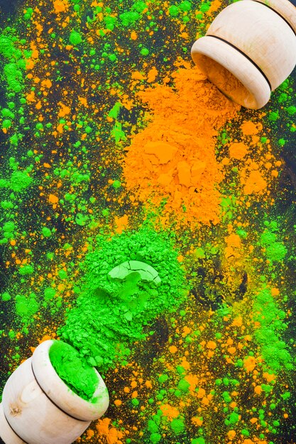 An overhead view of wooden spilled bowl of holi colors