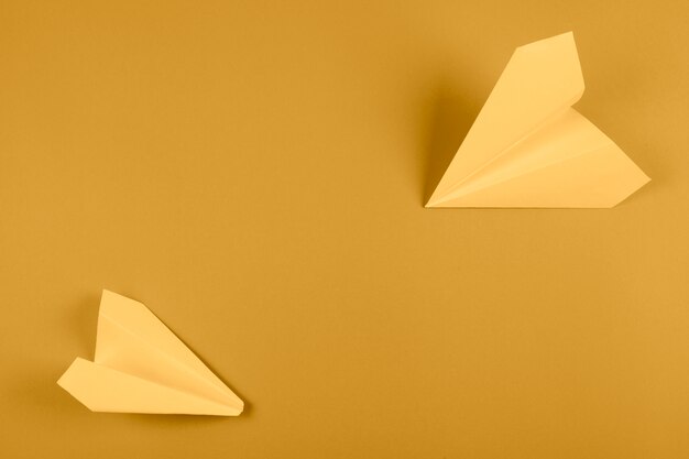 Вид сверху желтый бумажный самолетик на ярком цветном фоне