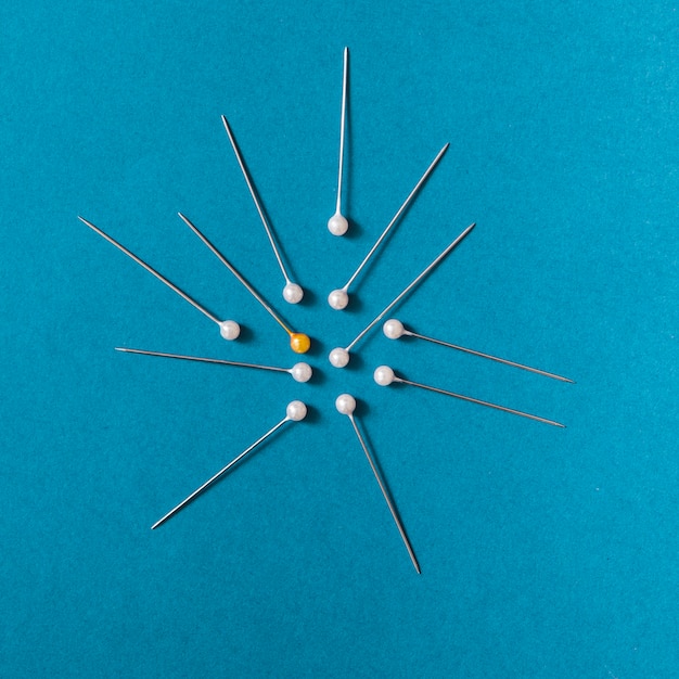 Free photo overhead view of yellow push pins with white pins on blue background