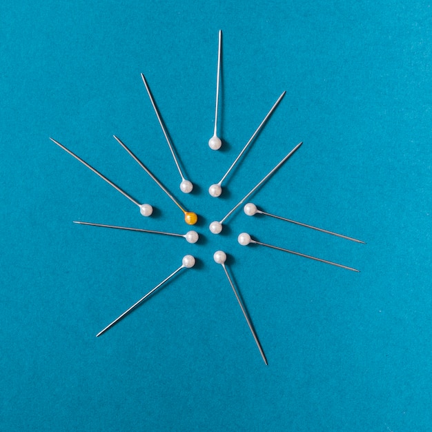 Overhead view of yellow push pins with white pins on blue background