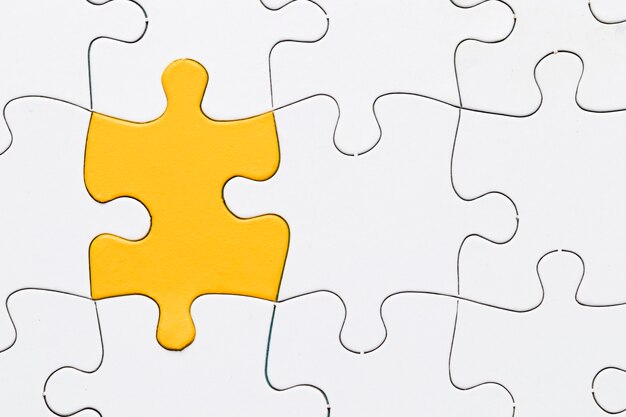 An overhead view of yellow puzzle among white piece