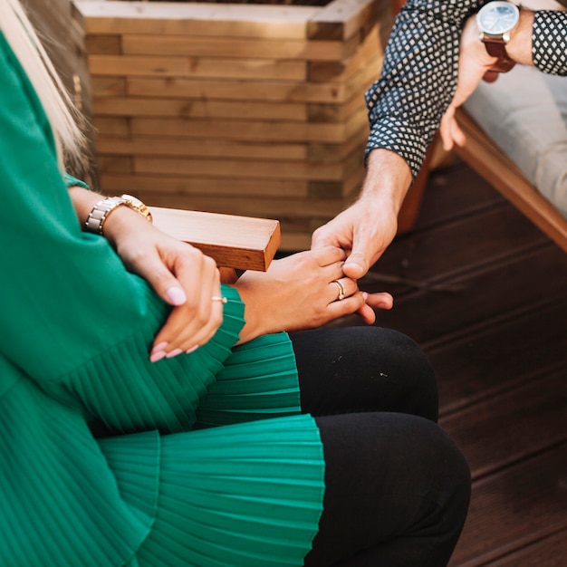 Free photo overhead view of young couple holding each other's hand