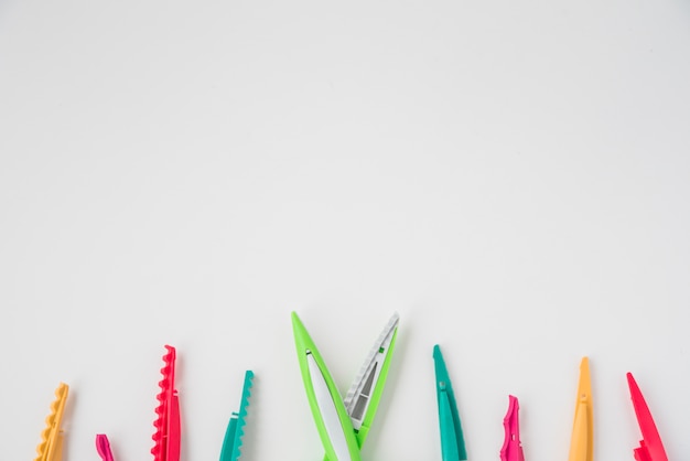 Overhead view of zigzag scissor with colorful blades at the bottom of white background