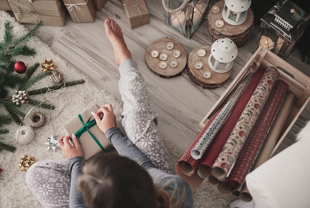 Overhead of woman tying a ribbon on gift