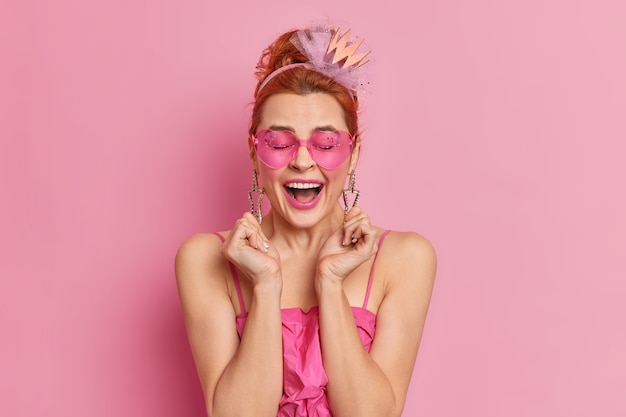 Overjoyed redhead young European woman raises hands